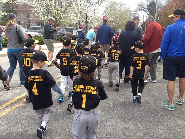 Team of kids wearing baseball team t-shirts with 'Jason Stone' above the player numbers.