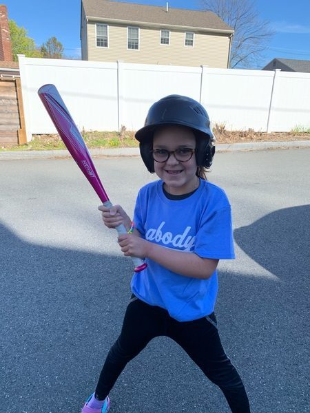 Child laughing while holding a baseball bat