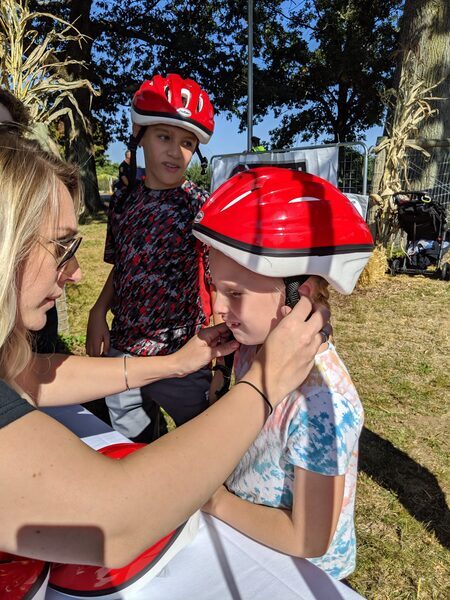 Woman securing a bicycle helmet on a child's head