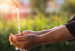 Hands cupping fresh, clean water spilling from one hand to the other